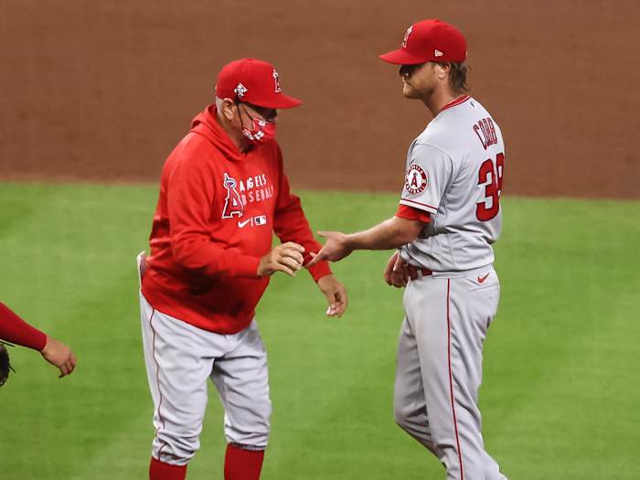 Los Angeles Angels manager Joe Maddon (right) gives the ball to relief pitcher Alex Claudio (58) in the sixth inning against the Texas Rangers at Angel Stadium.